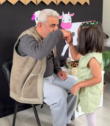 Merkezde düzenlenen bayram kutlamasında bir büyüğümüz, elini öpen küçük bir öğrencimizin elini öpüyor.